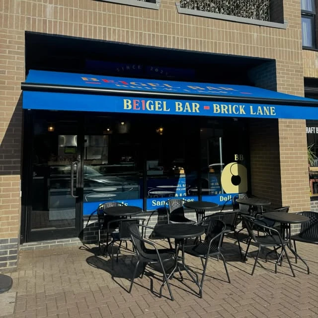 The blue and gold frontage of Beigel Bar Brick Lane in Ware